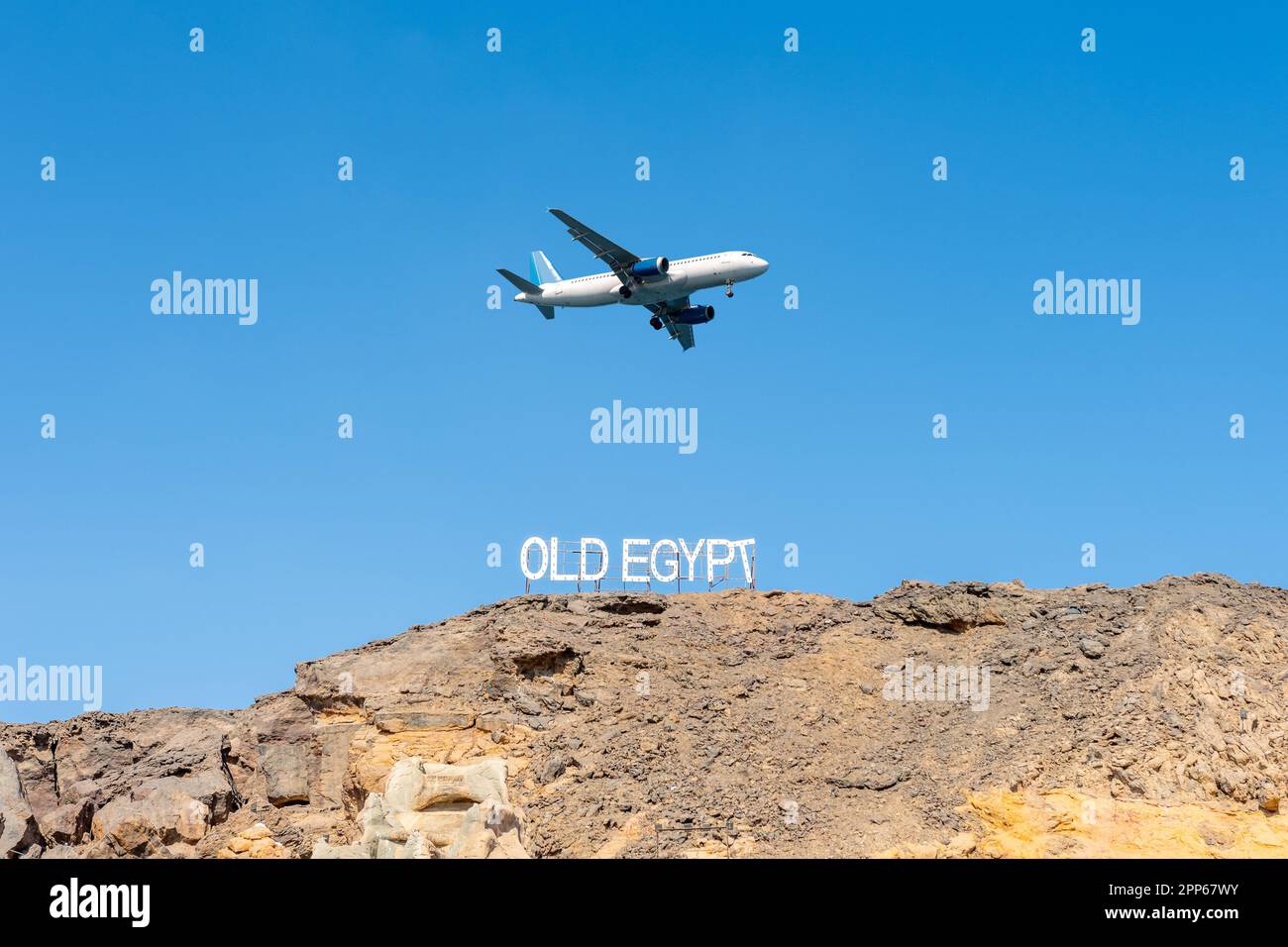 Panneau VIEILLE ÉGYPTE sur les rochers sur fond de ciel avec avion. Destination du voyage. Banque D'Images