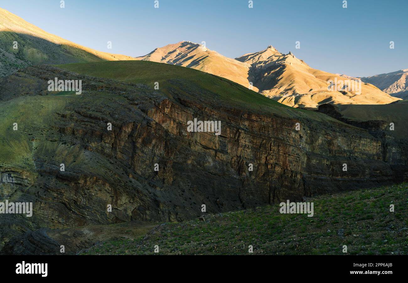 Vallée de Spiti avec vue sur les rochers accidentés, l'herbe, les sommets et les crêtes de l'Himalaya tous sous ciel clair bliue près de Kaza, Himachal Pradesh, Inde. Banque D'Images