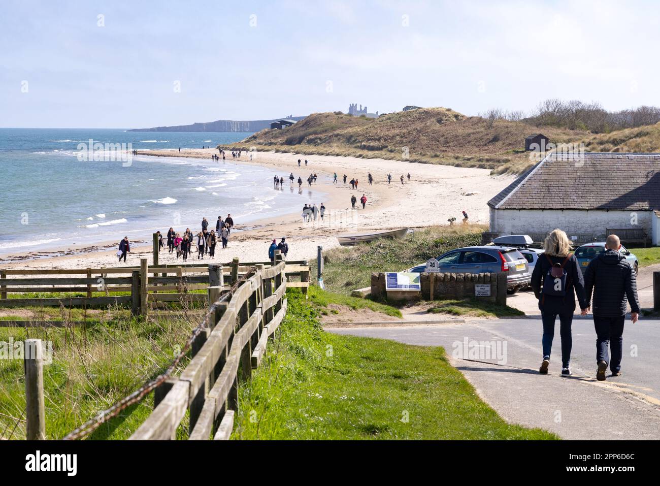 Plage de Northumberland; personnes marchant le long de la plage de Low