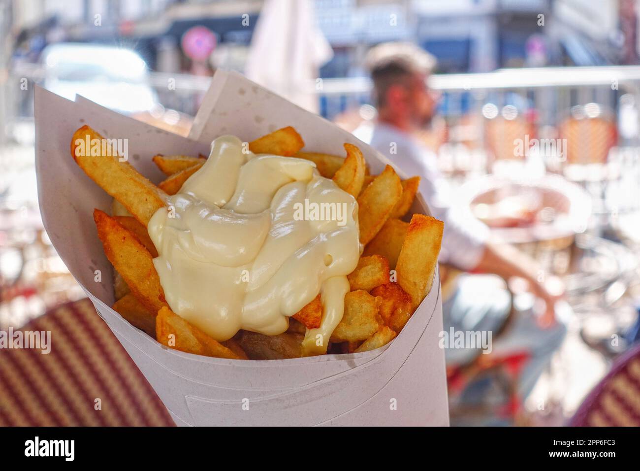 Frites belges avec mayonnaise servies dans un cône en papier Banque D'Images