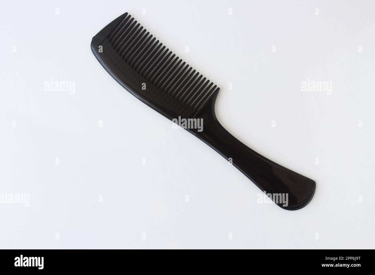 Vue de dessus sur une brosse à cheveux en plastique de couleur noire isolée sur fond blanc. Banque D'Images