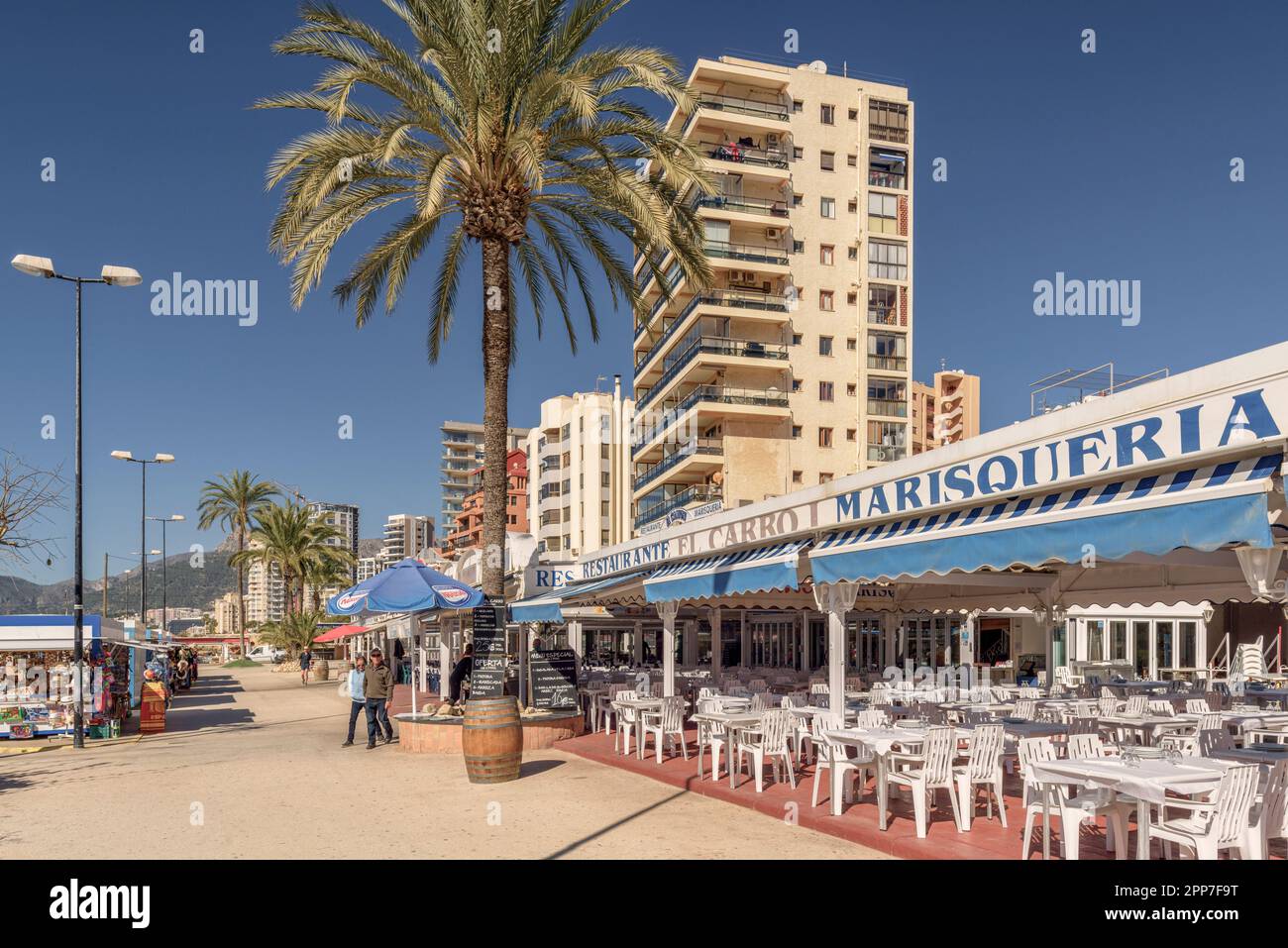 Personnes marchant par terrasses de bars, restaurants dans l'avenue du port de Calp (Calpe), province d'Alicante, Communauté Valencienne, Espagne, Europe Banque D'Images