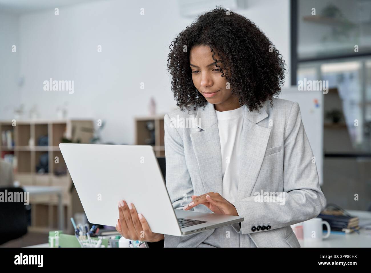 Femme d'affaires d'âge moyen travaillant, naviguant et tapant sur un ordinateur portable à écran tactile. Banque D'Images