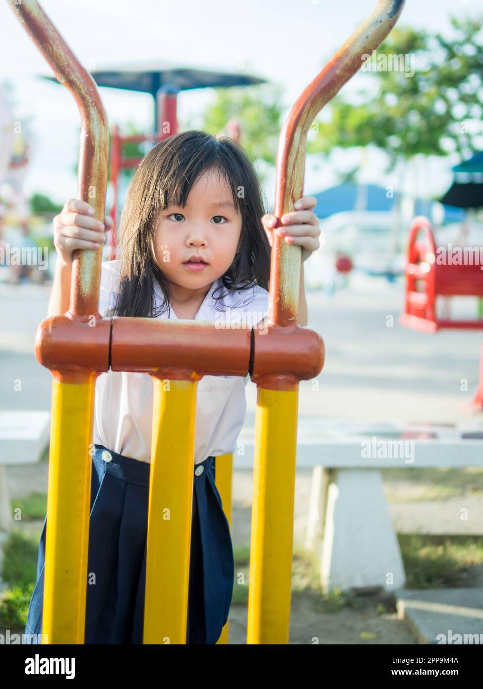 Joyeux enfant, enfant asiatique en uniforme scolaire jouant sur le terrain de jeu Banque D'Images