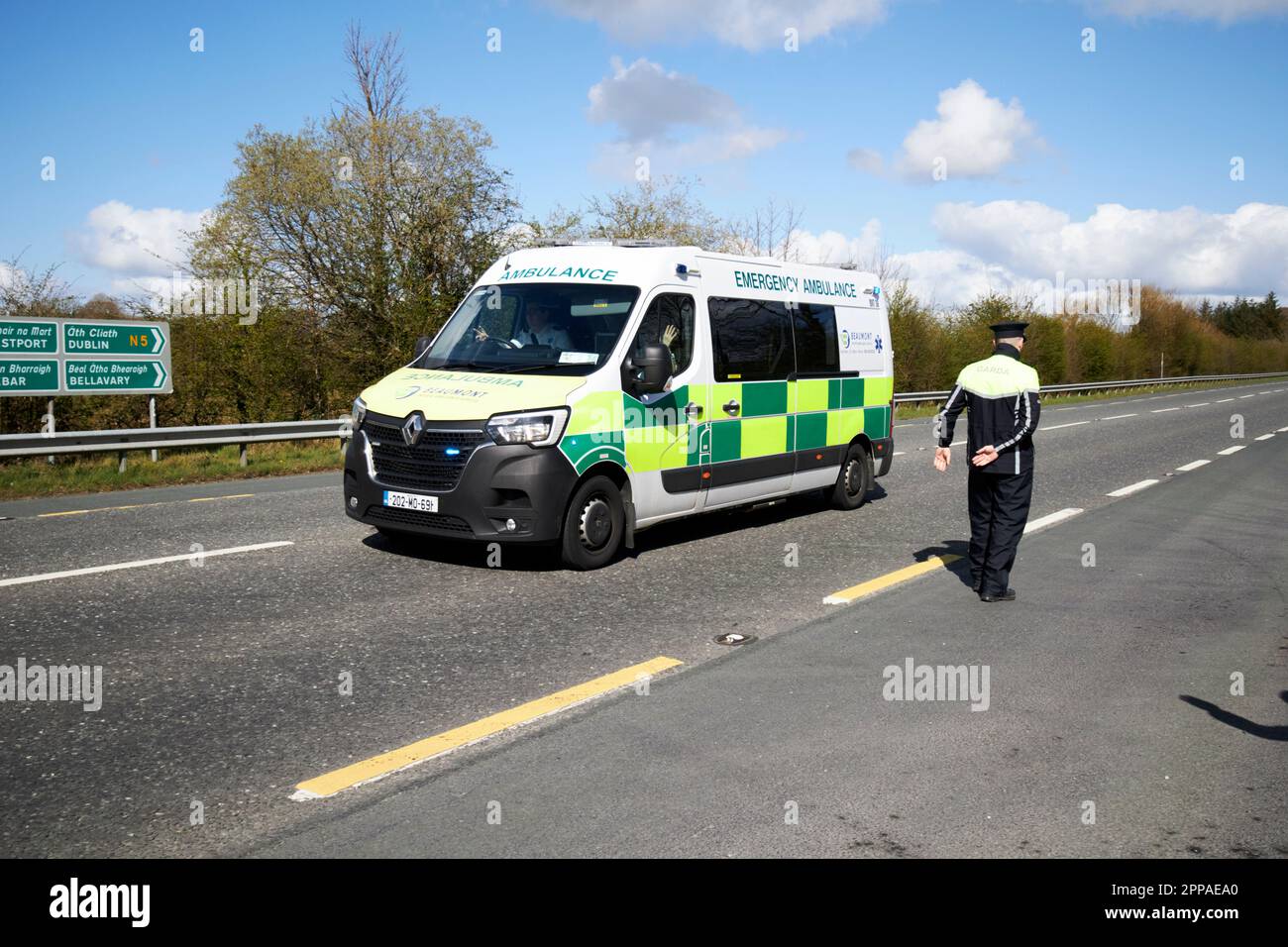 Le véhicule d'ambulance d'urgence privé de beaumont passe le policier irlandais faisant partie du carde du président bidens lors d'une visite officielle en Irlande le N5 ou Banque D'Images
