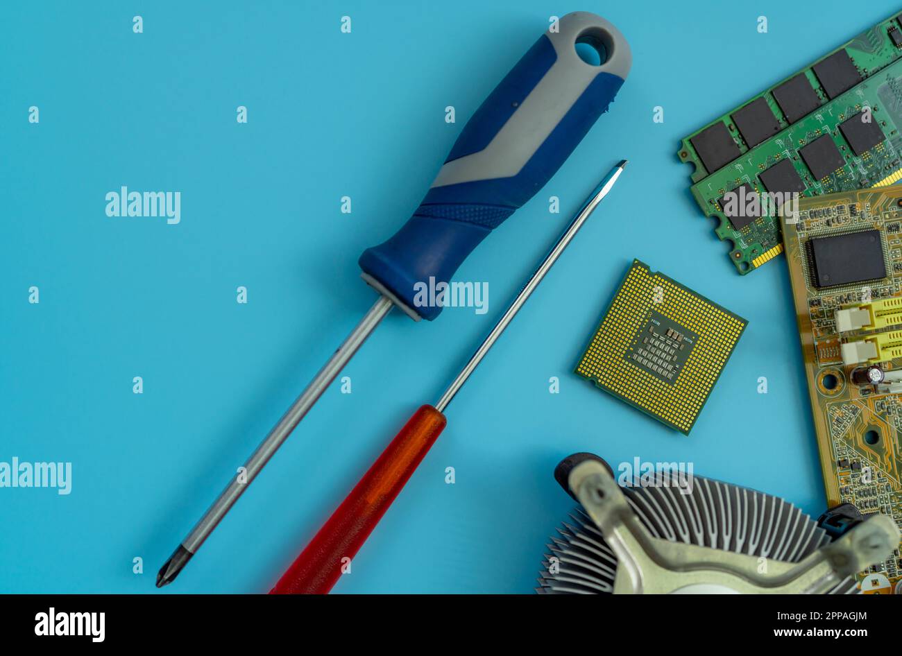 Puce informatique de la carte mère du PC et tournevis à l'atelier de réparation. Vue de dessus du chipset du processeur sur fond bleu. Composants électroniques. Matériel informatique. Banque D'Images