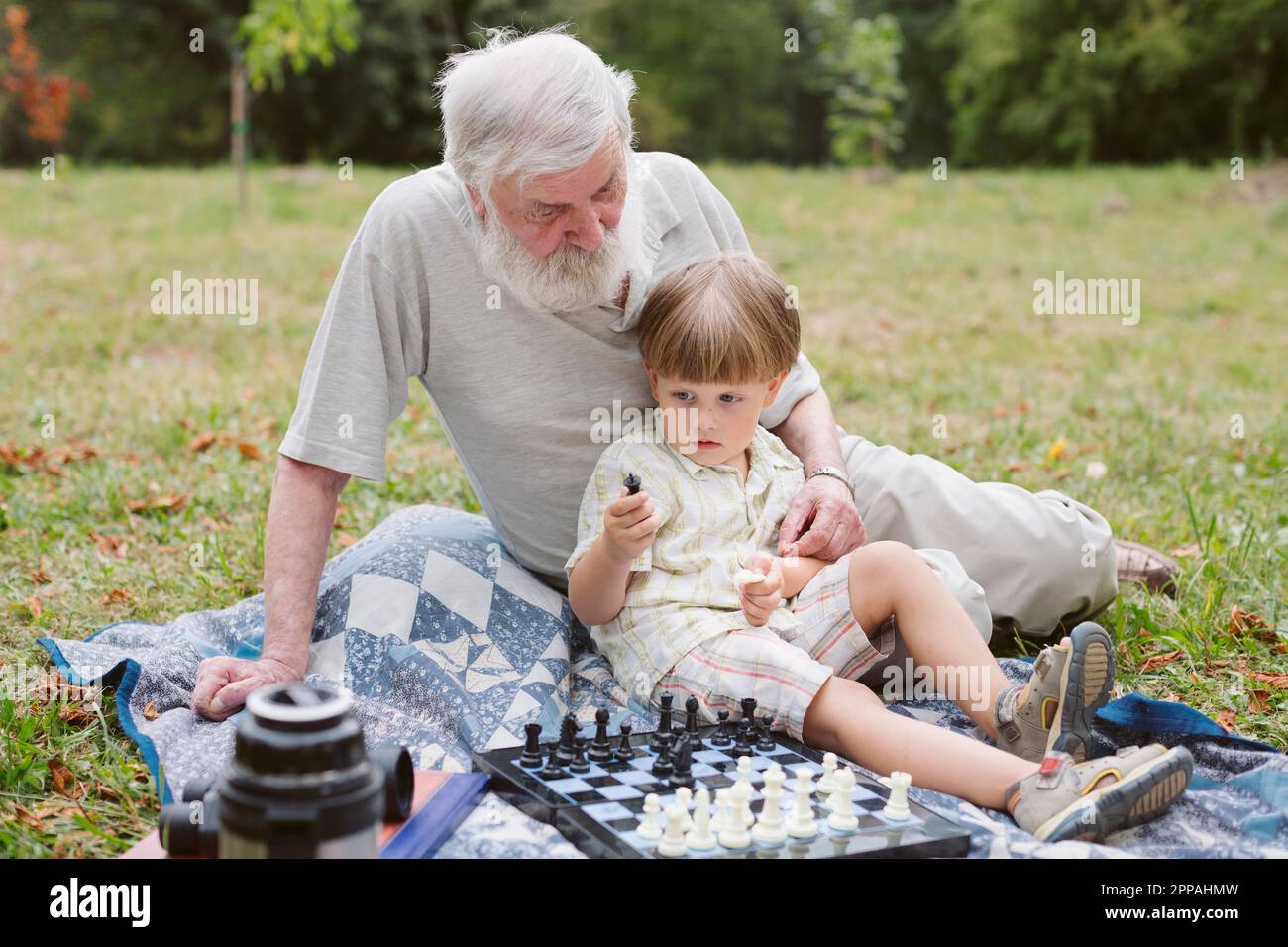 Vue de face petit-fils assis avec grand-père Banque D'Images