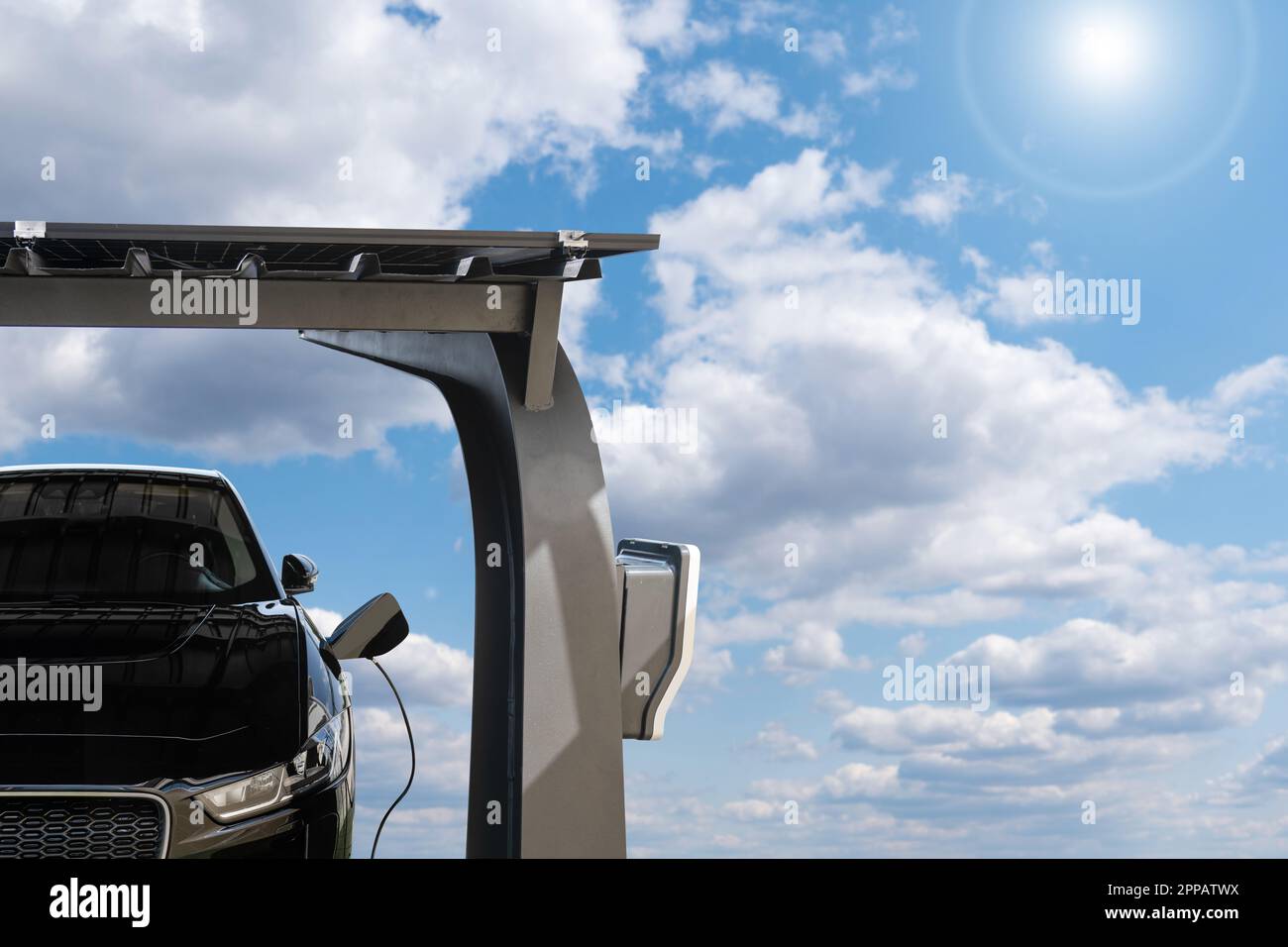 La voiture électrique est chargée à partir d'une station de charge qui prend l'énergie des panneaux solaires. Photo de haute qualité Banque D'Images