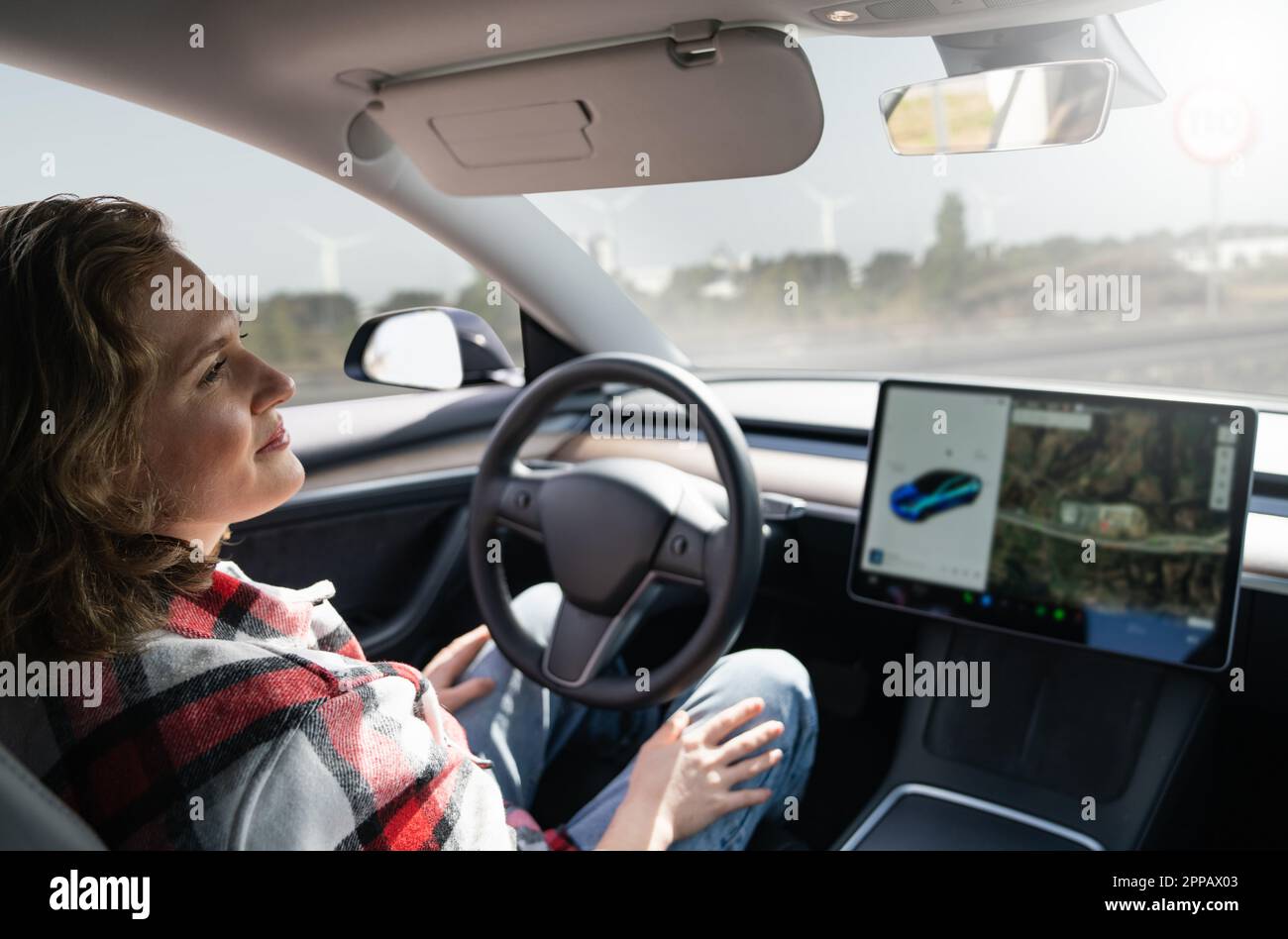 Femme se reposant pendant que sa voiture est conduite par un pilote automatique. Concept de véhicule à conduite automatique. Banque D'Images