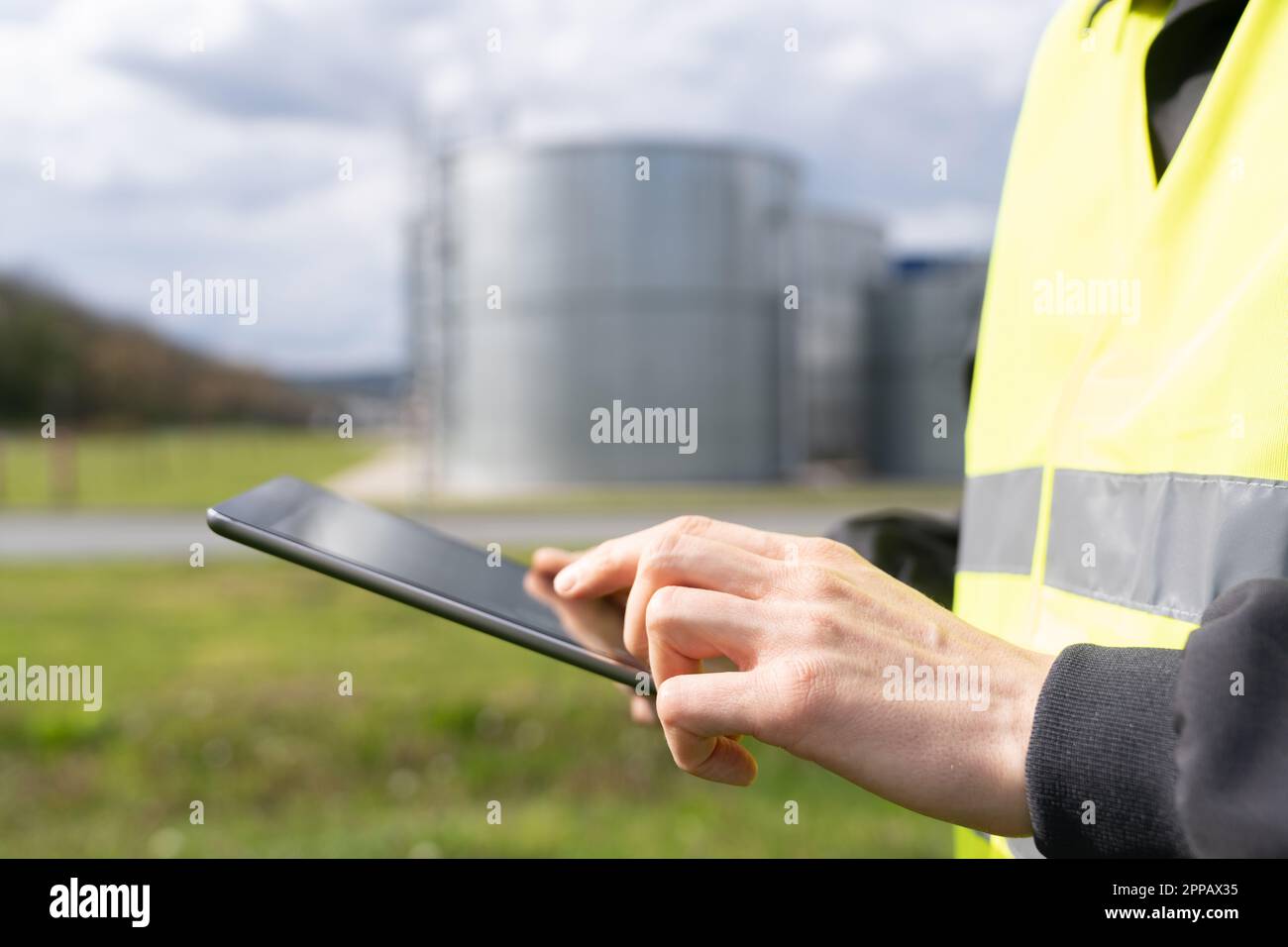 Concevoir avec une tablette numérique sur un fond de réservoirs de gaz. Photo de haute qualité Banque D'Images