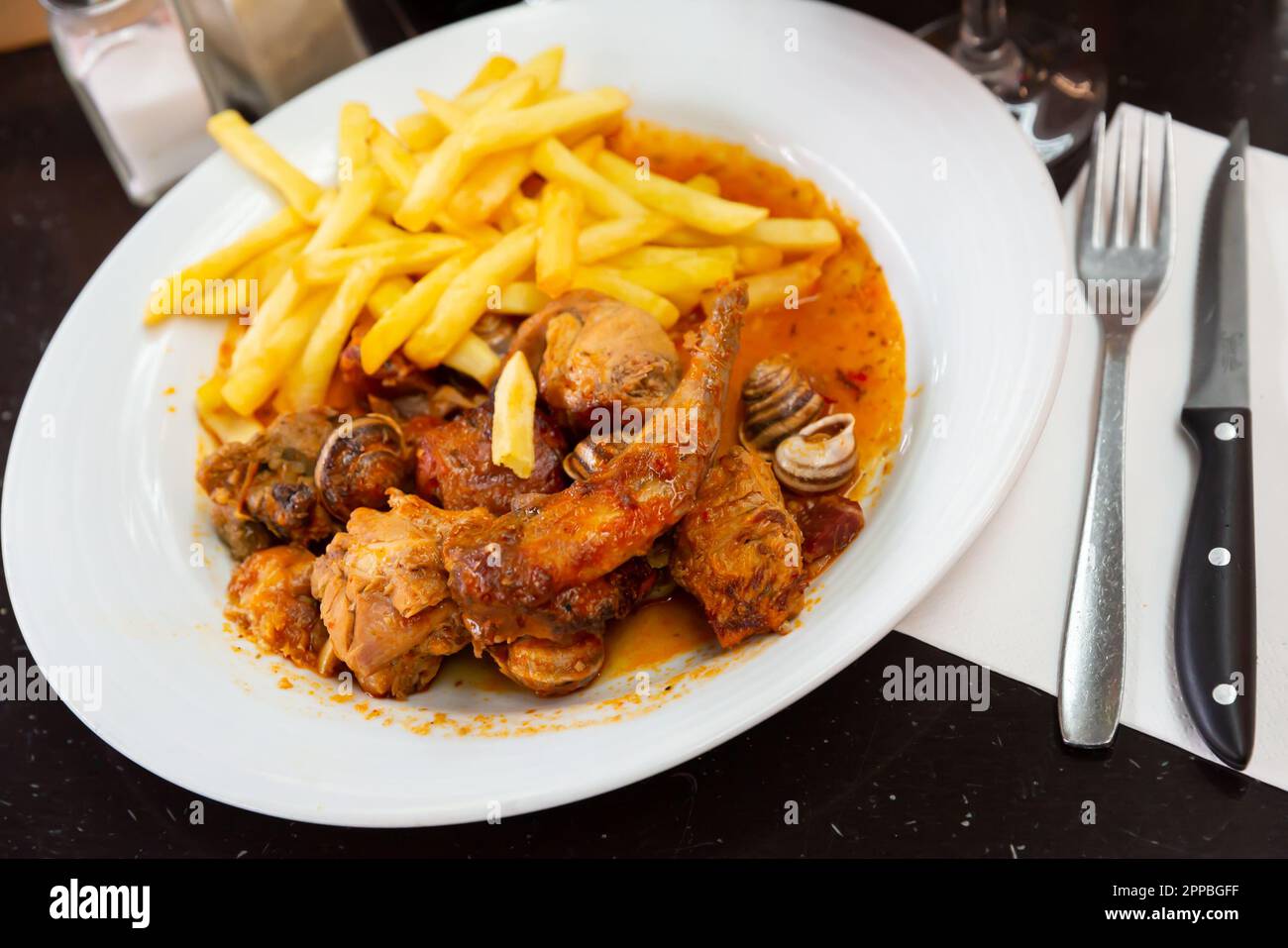 Mâché de lapin à sause avec des escargots, servi avec des frites Banque D'Images