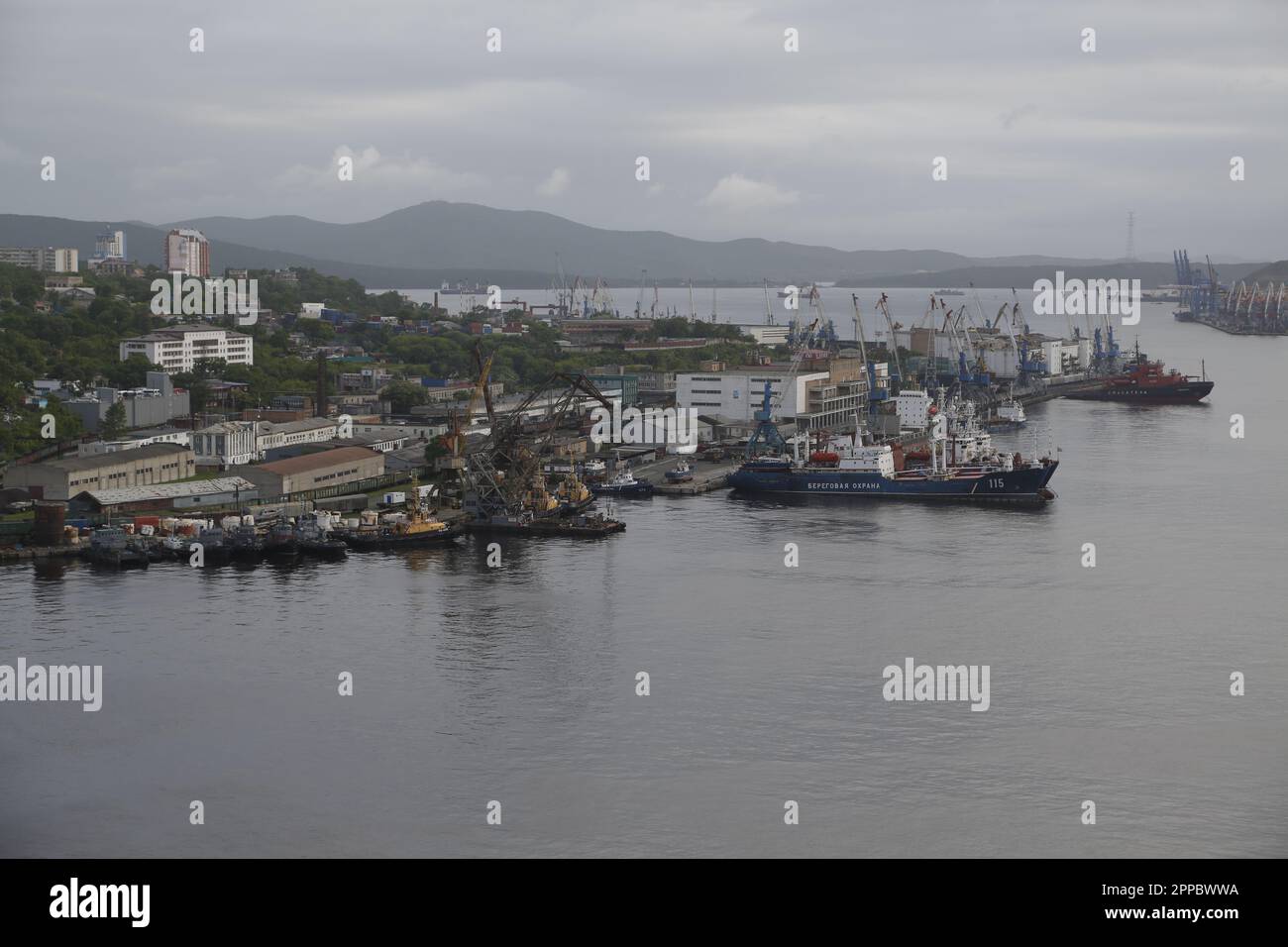 Vue sur le port de Vladivostok, Russie, avec navire de la Garde côtière russe, un navire de sauvetage et de nombreuses grues portuaires Banque D'Images