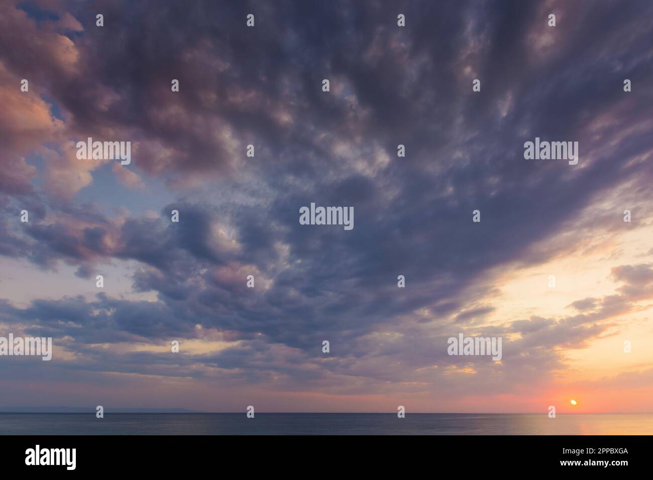 aube spectaculaire en mer. nuages gris sur le ciel avec soleil rouge au-dessus de l'horizon. vacances d'été météo pluvieuse Banque D'Images