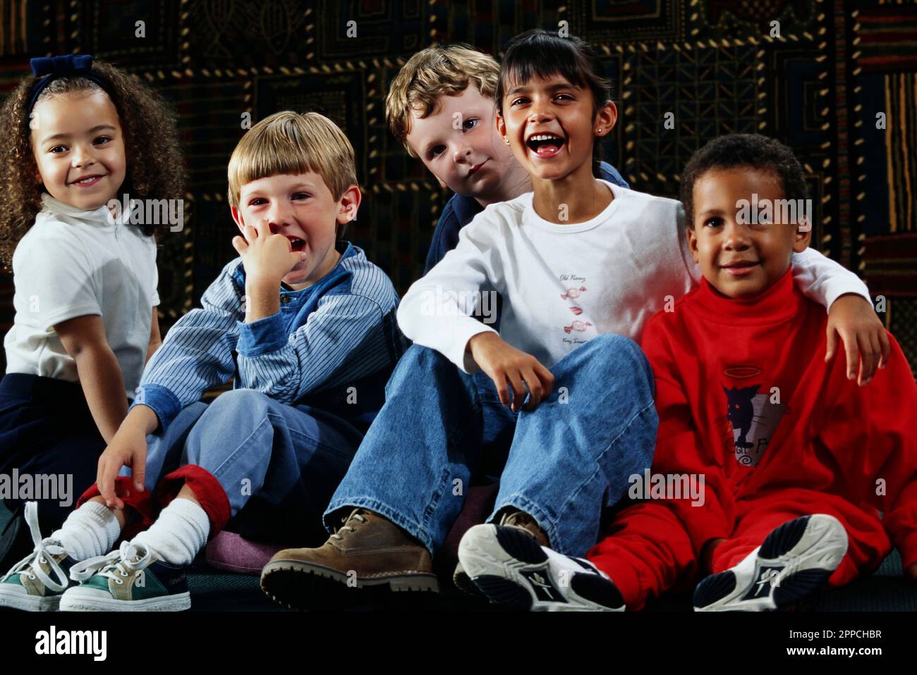 Portrait d'un groupe d'enfants multiraciaux à l'écoute et au rire Banque D'Images