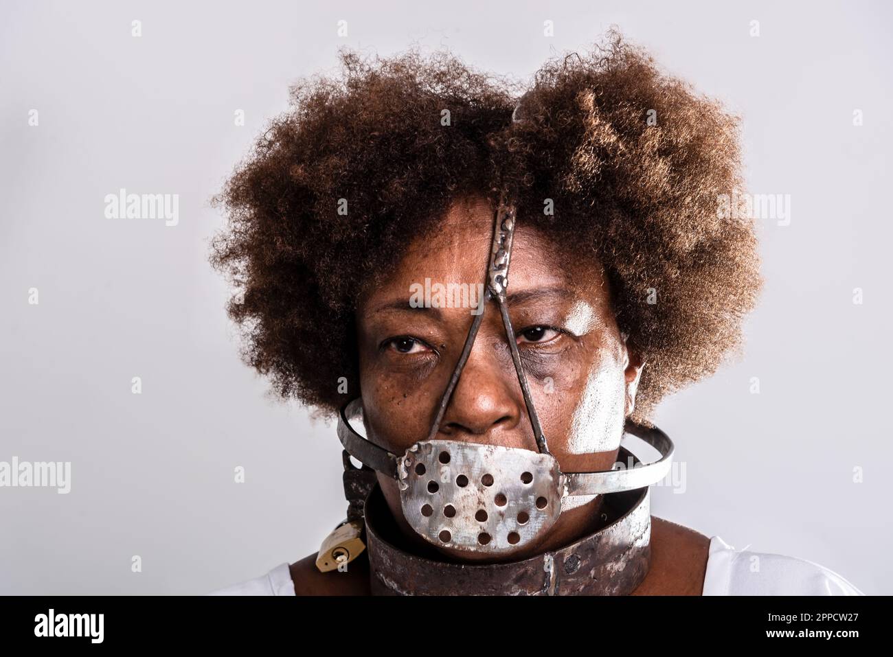 Portrait de visage de femme noire avec masque en fer de l'esclavage couvrant sa bouche. Reproduction en studio. Banque D'Images