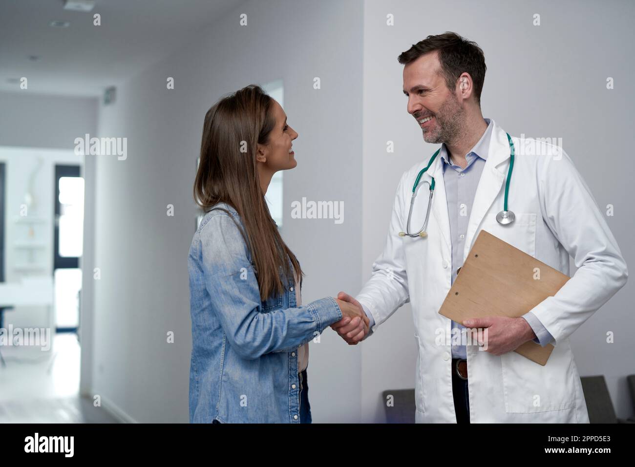 Un médecin mature se secouant la main avec le patient à la clinique Banque D'Images