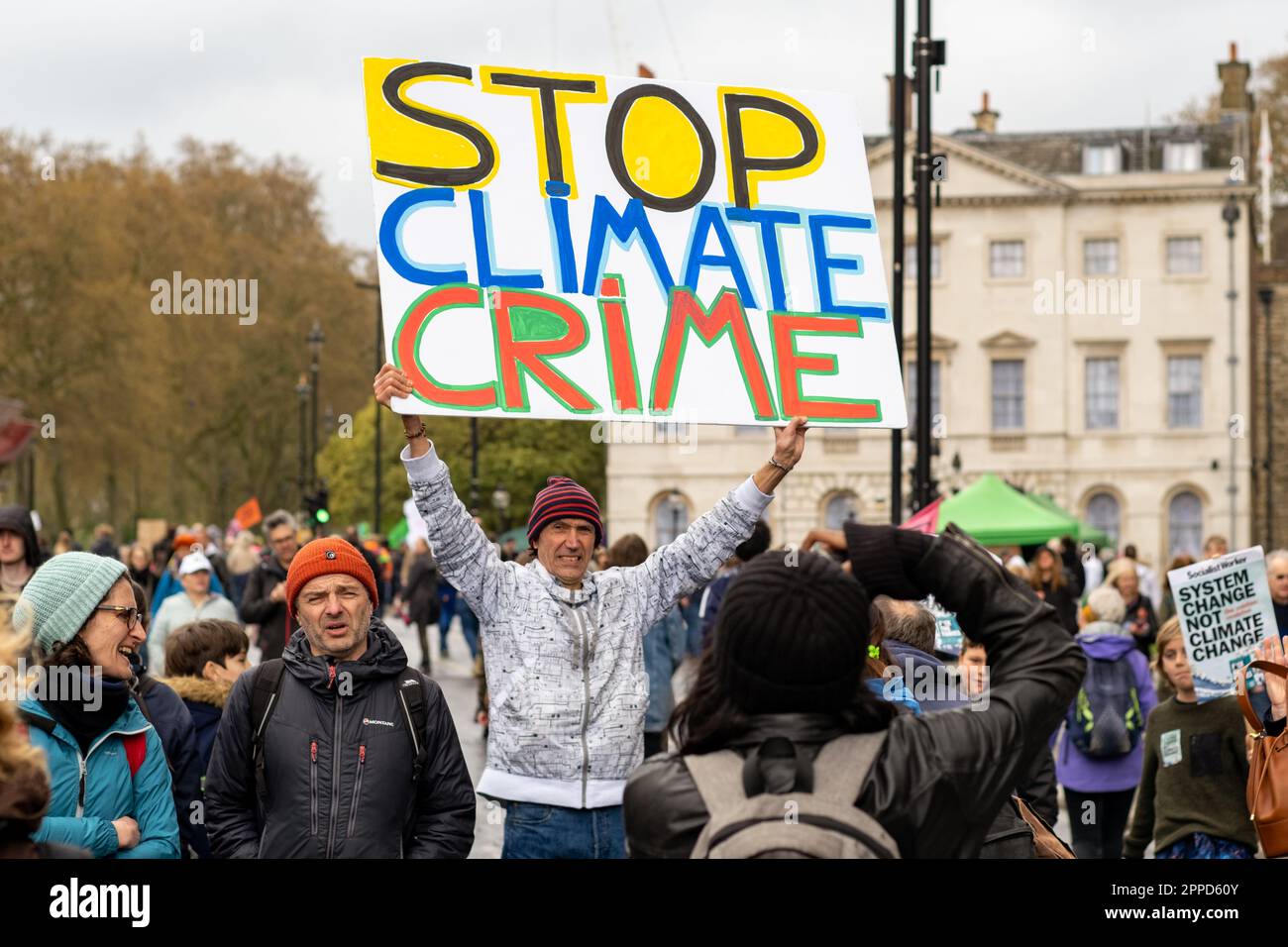 La rébellion de l'extinction « The Big One », a organisé un week-end de protestation. Man tient une grande bannière de protestation devant Westminster. Avril 2023. Banque D'Images