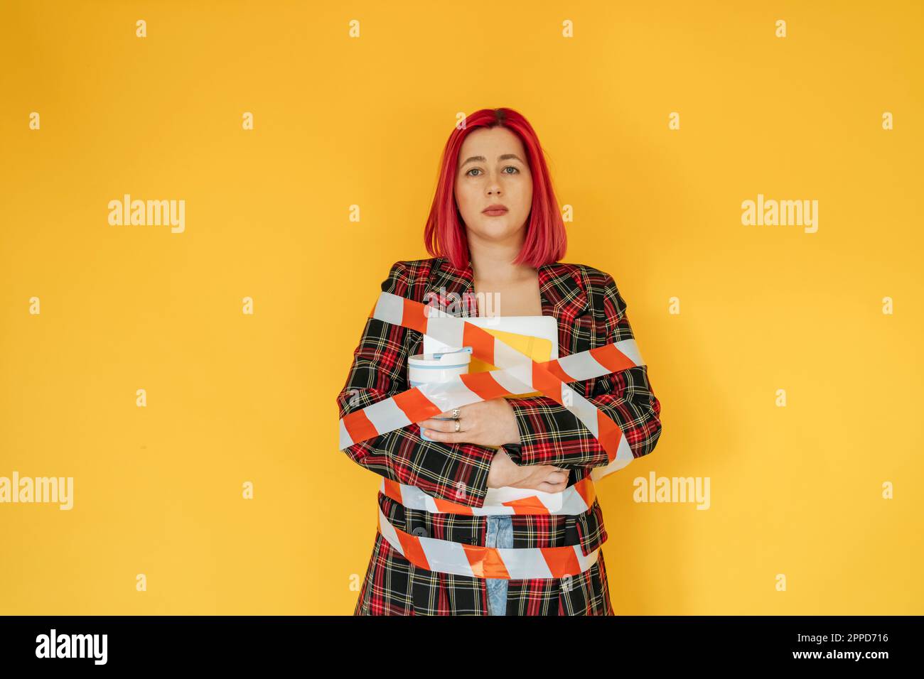 Triste femme attachée avec bande sur fond jaune Banque D'Images