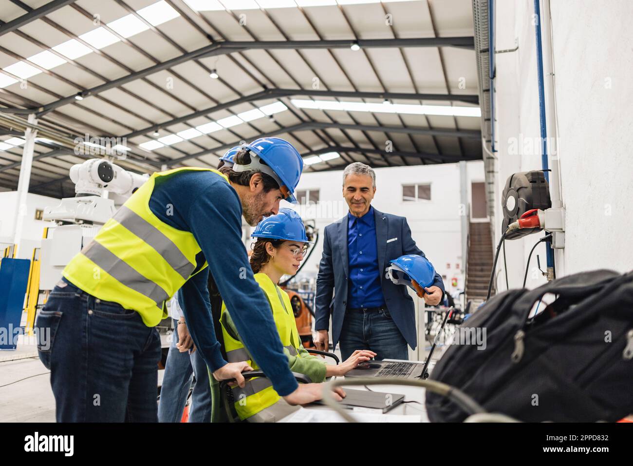 Les ingénieurs discutent en usine avec un ordinateur portable Banque D'Images