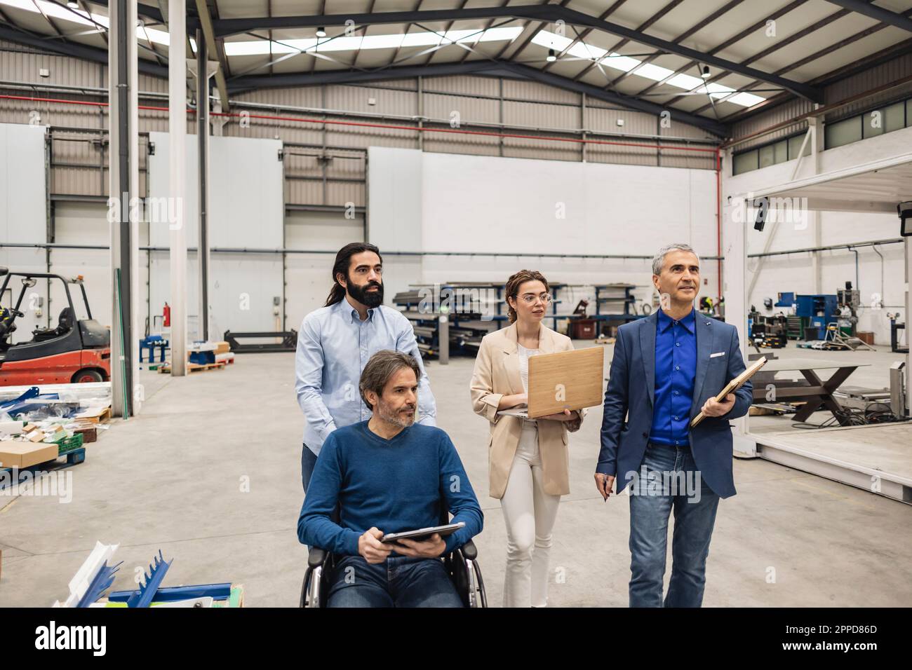 Ingénieur handicapé en discussion avec des collègues en usine Banque D'Images