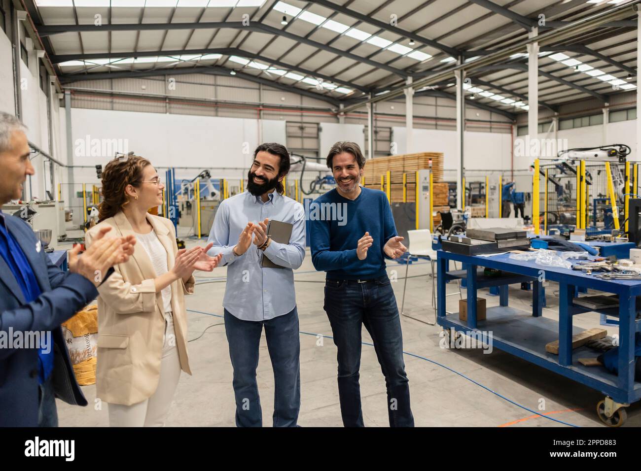 Des ingénieurs heureux applaudissent ensemble dans l'industrie Banque D'Images
