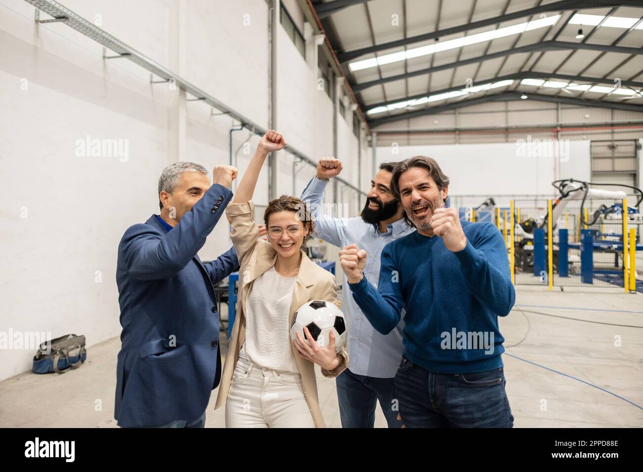 Des ingénieurs joyeux applaudissent ensemble dans l'industrie Banque D'Images