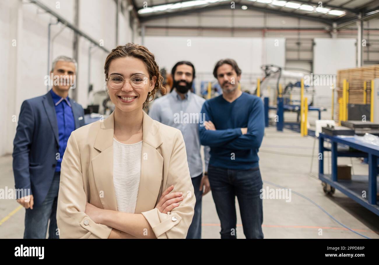 Un ingénieur heureux debout avec les bras croisés devant ses collègues Banque D'Images