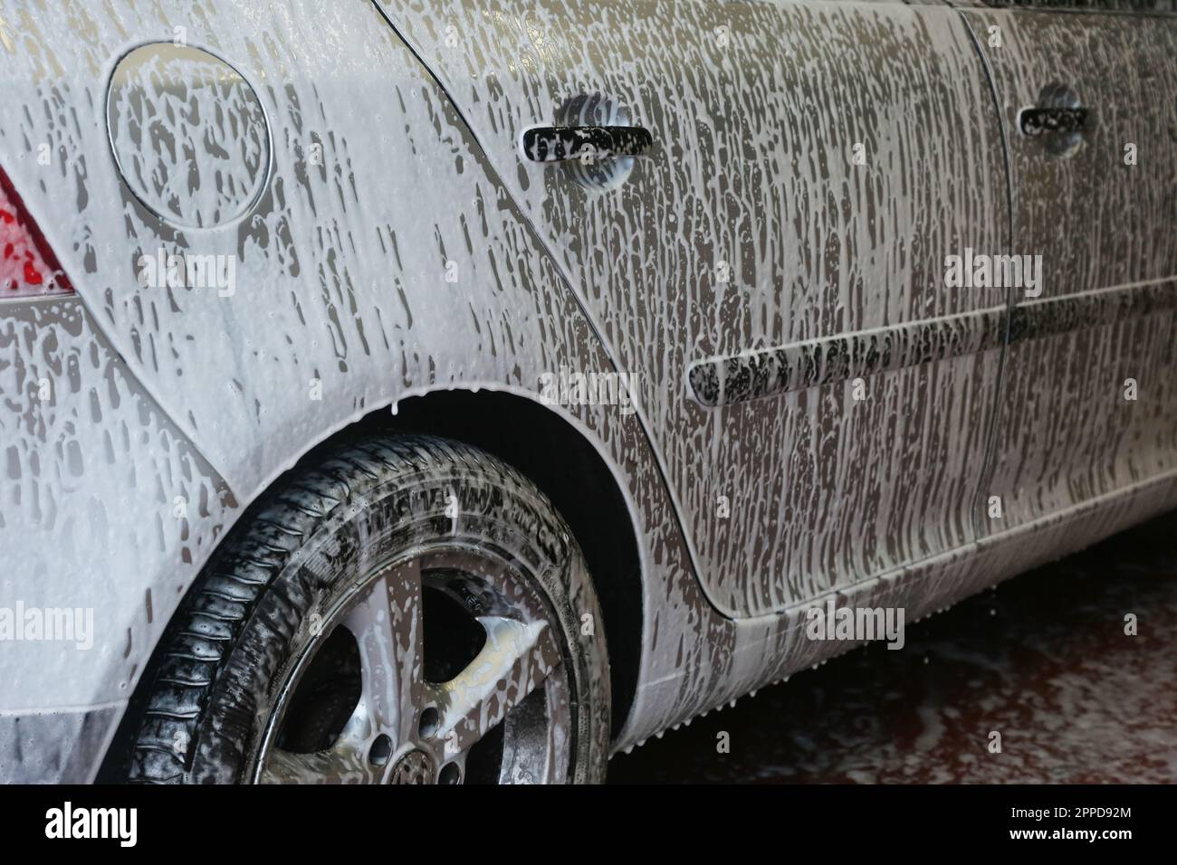 La voiture est d'abord lavée avec du savon pour la nettoyer. Banque D'Images