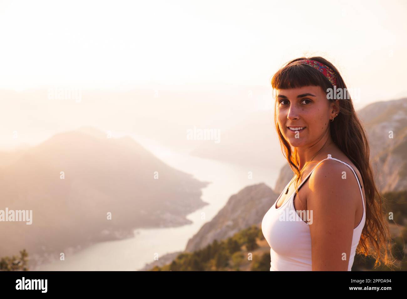 Femme souriante debout devant les montagnes Banque D'Images