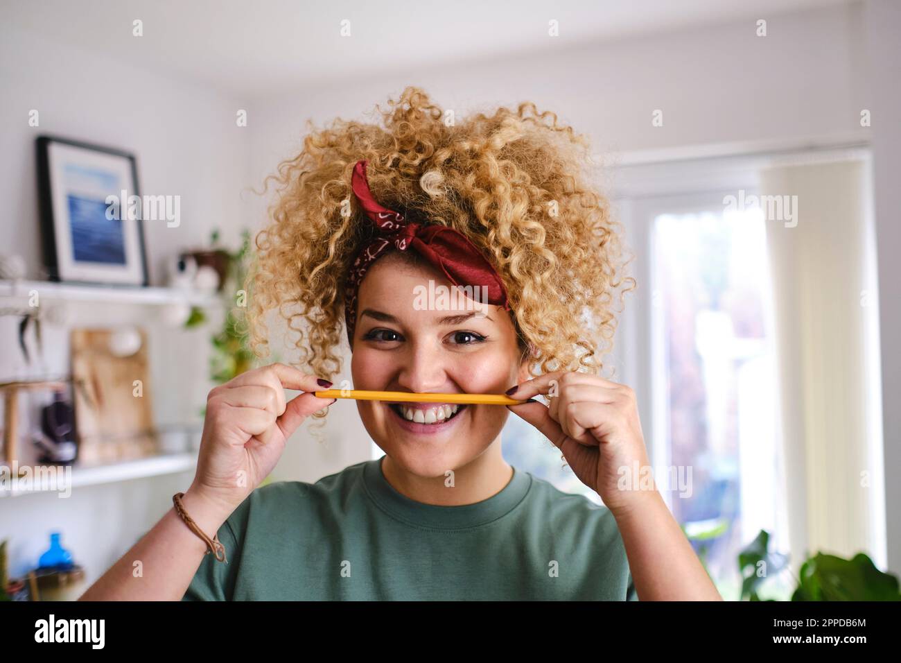 Bonne femme tenant le crayon sur les lèvres Banque D'Images