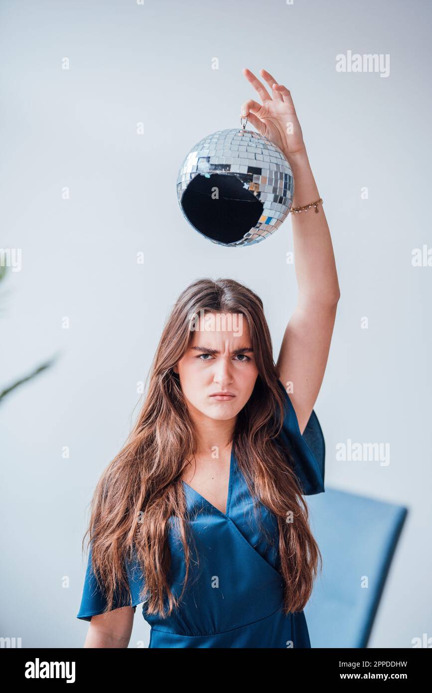 Femme d'affaires furieuse tenant une balle disco cassée sur la tête Banque D'Images