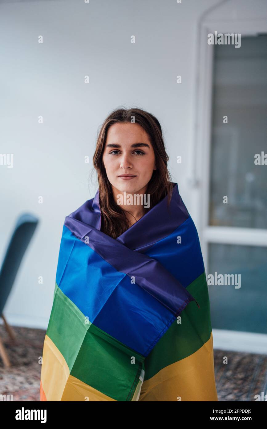 Femme d'affaires enveloppée d'un drapeau arc-en-ciel Banque D'Images
