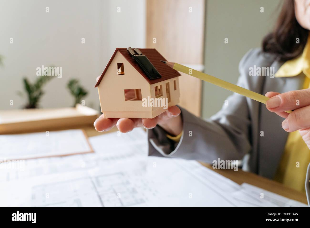 Agent immobilier avec crayon de pointage de maison modèle sur panneau solaire Banque D'Images