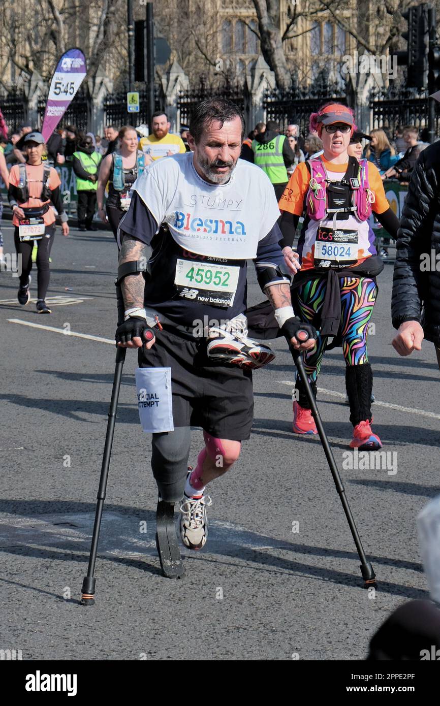 Londres, Royaume-Uni. 25th mars 2023. Un coureur de marathon sur des  béquilles est presque à la fin de leur voyage après avoir atteint la place  du Parlement. Six heures après le début