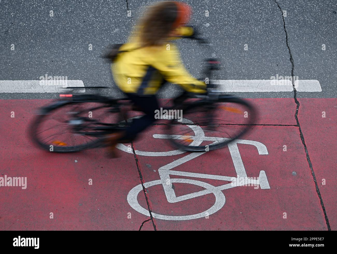 PRODUCTION - 20 avril 2023, Hesse, Francfort-sur-le-main : une cycliste féminine se trouve dans une piste cyclable rouge du centre-ville (prise avec une vitesse d'obturation plus longue). Sur 24 avril 2023, l'ADFC présentera les résultats de l'essai climatique 2022 de la bicyclette pour Hesse. L'enquête de l'automne 2022 vise à fournir des renseignements sur les municipalités de Hesse qui sont particulièrement adaptées aux vélos - et sur les endroits où il est nécessaire de rattraper leur retard. Dans le test de climat à vélo, les citoyens des municipalités allemandes sont interrogés sur leur convivialité à vélo. Photo: Arne Dedert/dpa Banque D'Images
