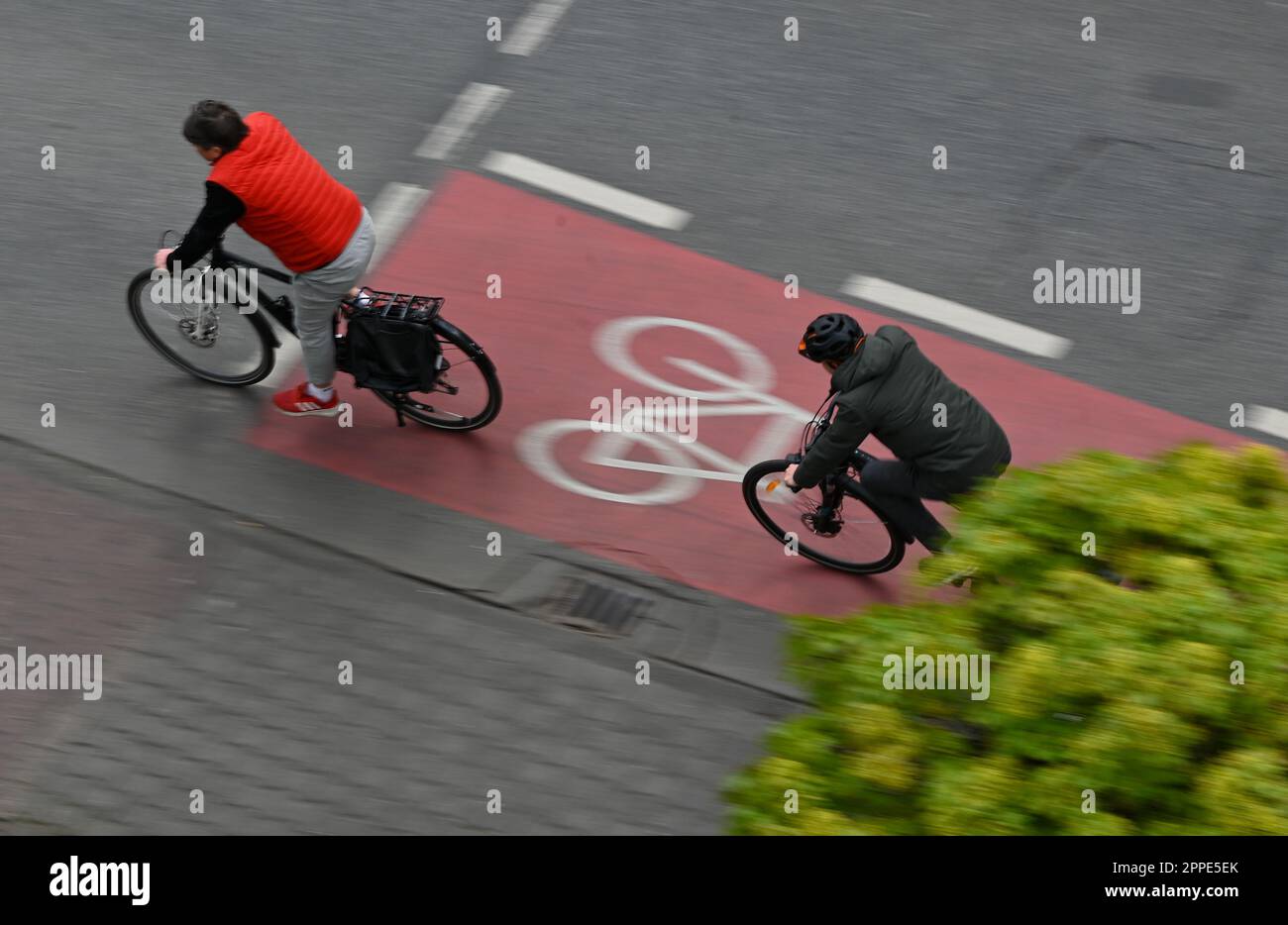 PRODUCTION - 20 avril 2023, Hesse, Francfort-sur-le-main : deux cyclistes sont sur une piste cyclable rouge dans le centre-ville (tourné avec une vitesse d'obturation plus longue). Sur 24 avril 2023, l'ADFC présentera les résultats de l'essai climatique 2022 de la bicyclette pour Hesse. L'enquête de l'automne 2022 vise à fournir des renseignements sur les municipalités de Hesse qui sont particulièrement adaptées aux vélos - et sur les endroits où il est nécessaire de rattraper leur retard. Dans le test de climat à vélo, les citoyens des municipalités allemandes sont interrogés sur leur convivialité à vélo. Photo: Arne Dedert/dpa Banque D'Images