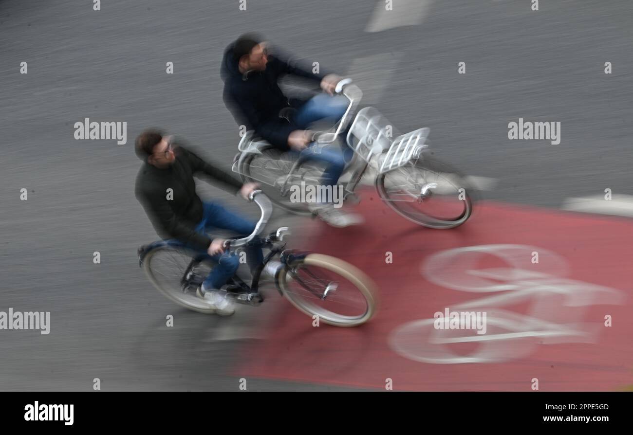 PRODUCTION - 20 avril 2023, Hesse, Francfort-sur-le-main : deux cyclistes sont sur une piste cyclable rouge dans le centre-ville (tourné avec une vitesse d'obturation plus longue). Sur 24 avril 2023, l'ADFC présentera les résultats de l'essai climatique 2022 de la bicyclette pour Hesse. L'enquête de l'automne 2022 vise à fournir des renseignements sur les municipalités de Hesse qui sont particulièrement adaptées aux vélos - et sur les endroits où il est nécessaire de rattraper leur retard. Dans le test de climat à vélo, les citoyens des municipalités allemandes sont interrogés sur leur convivialité à vélo. Photo: Arne Dedert/dpa Banque D'Images