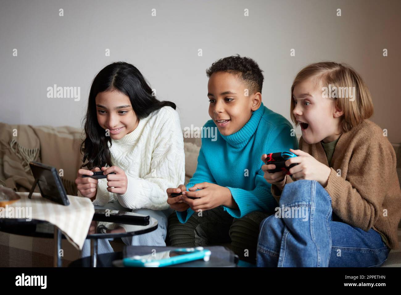 Enfants jouant à des jeux vidéo à la maison Banque D'Images