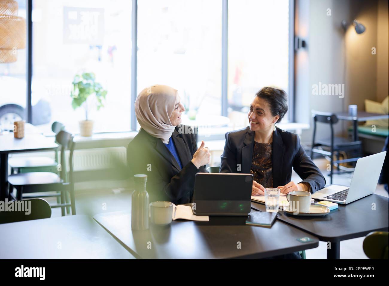 Businesswomen talking in cafe Banque D'Images