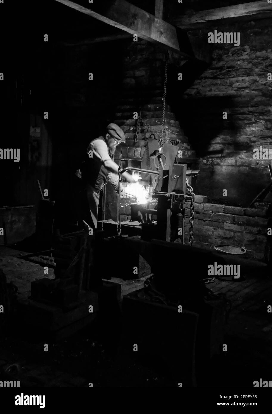 Forgeron volontaire forgeant des maillons de chaîne, Black Country Living Museum. Mars 2023 Banque D'Images