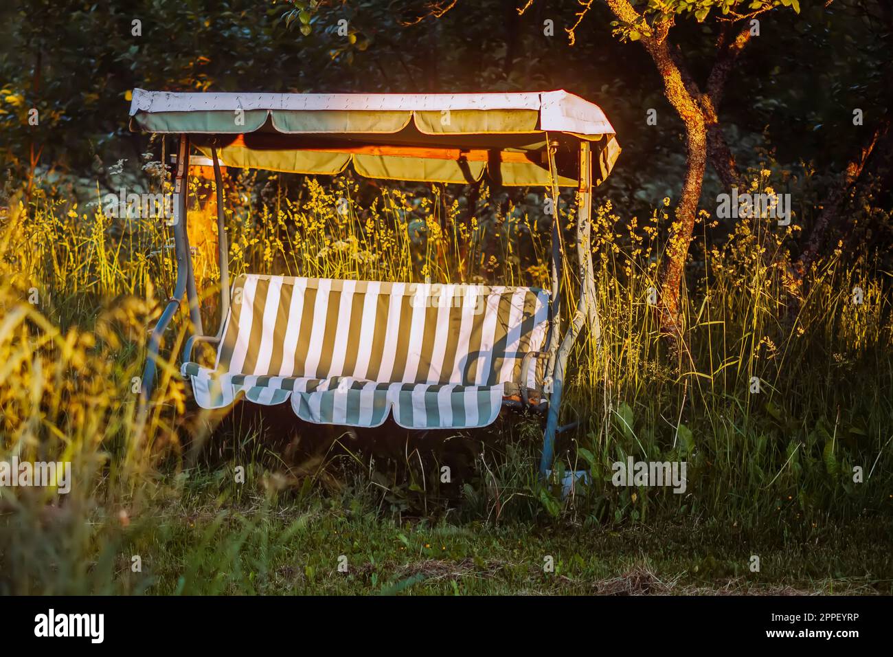 Balancer dans le jardin. Meubles de jardin en métal et toile rayée. Banque D'Images