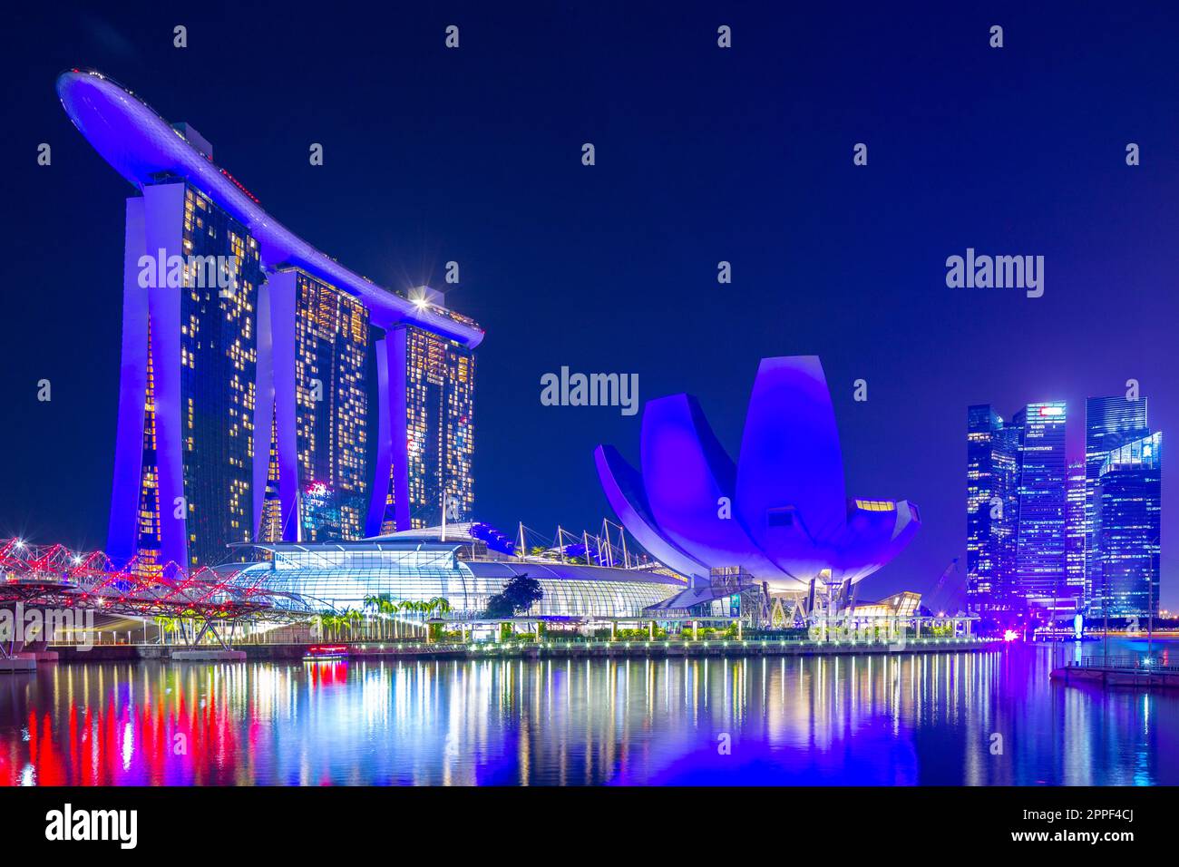 Vue nocturne sur Marina Bay à Singapour, y compris le Marina Bay Sands Hotel et le musée ArtScience en forme de lotus. Banque D'Images