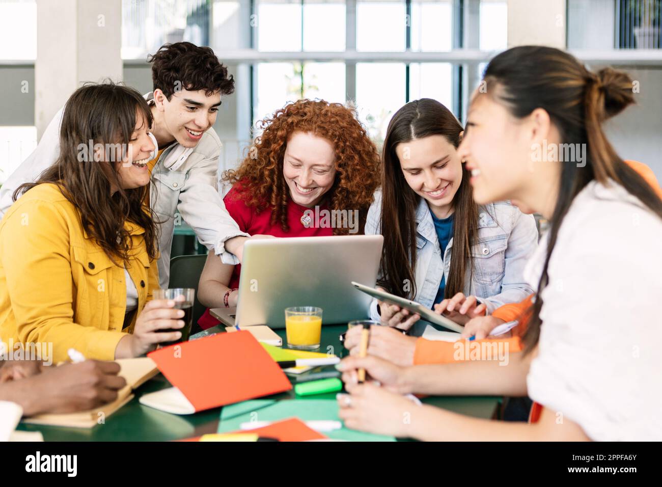 Divers groupes d'étudiants étudient ensemble à la cafétéria de l'université Banque D'Images