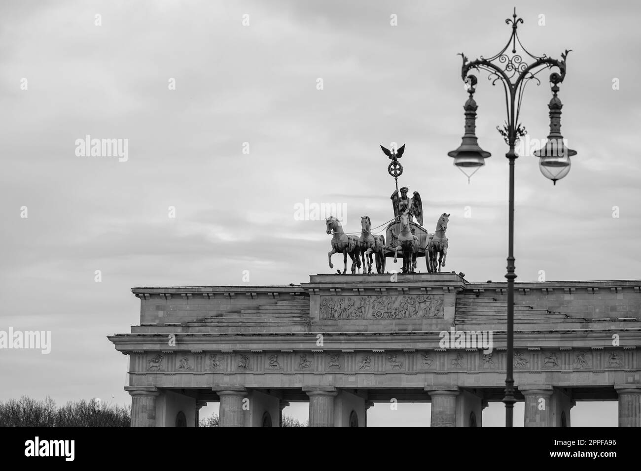 Berlin, Allemagne - 18 avril 2023 : vue sur une lampe de rue décorée et la Quadriga, la statue en haut de la porte de Brandebourg à Berlin Allemagne Banque D'Images
