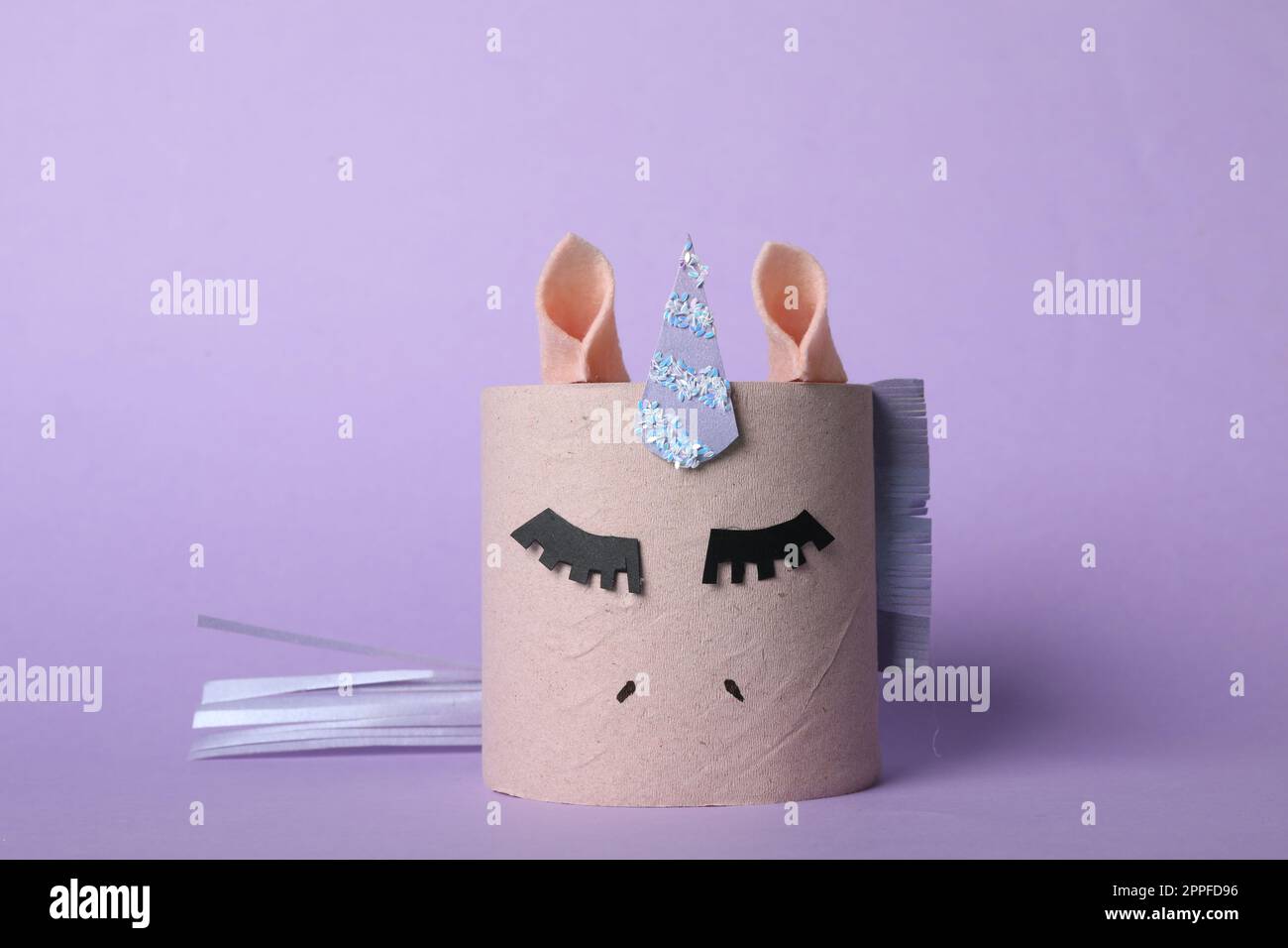 licorne de jouet en rouleau de papier toilette sur fond lilas Banque D'Images