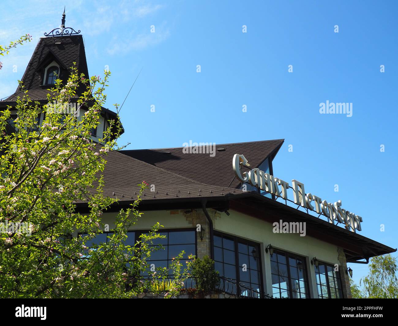 Stanisici, Bijelina, Bosnie-Herzégovine, 25 avril 2021. Bâtiment moderne et élégant du St. Restaurant Petersburg, toit et girouette. Ciel bleu et bouleau. L'inscription - St. Petersburg Banque D'Images
