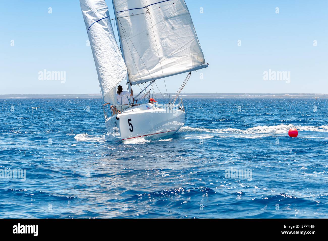 Petit yacht blanc pendant la régate de voile Banque D'Images