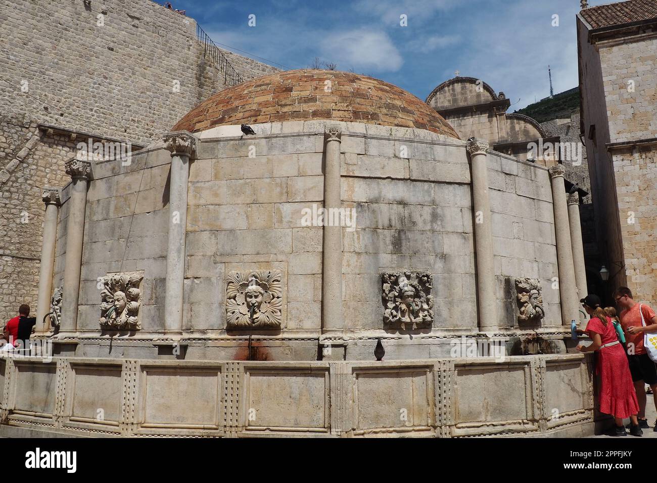 Dubrovnik, Croatie, 08.14.2022. Grande fontaine d'Onofrio. Un mascaron, un élément décoratif en forme de masque à caractère mythologique. Haut relief ou sculpture. Les gens et les touristes Banque D'Images