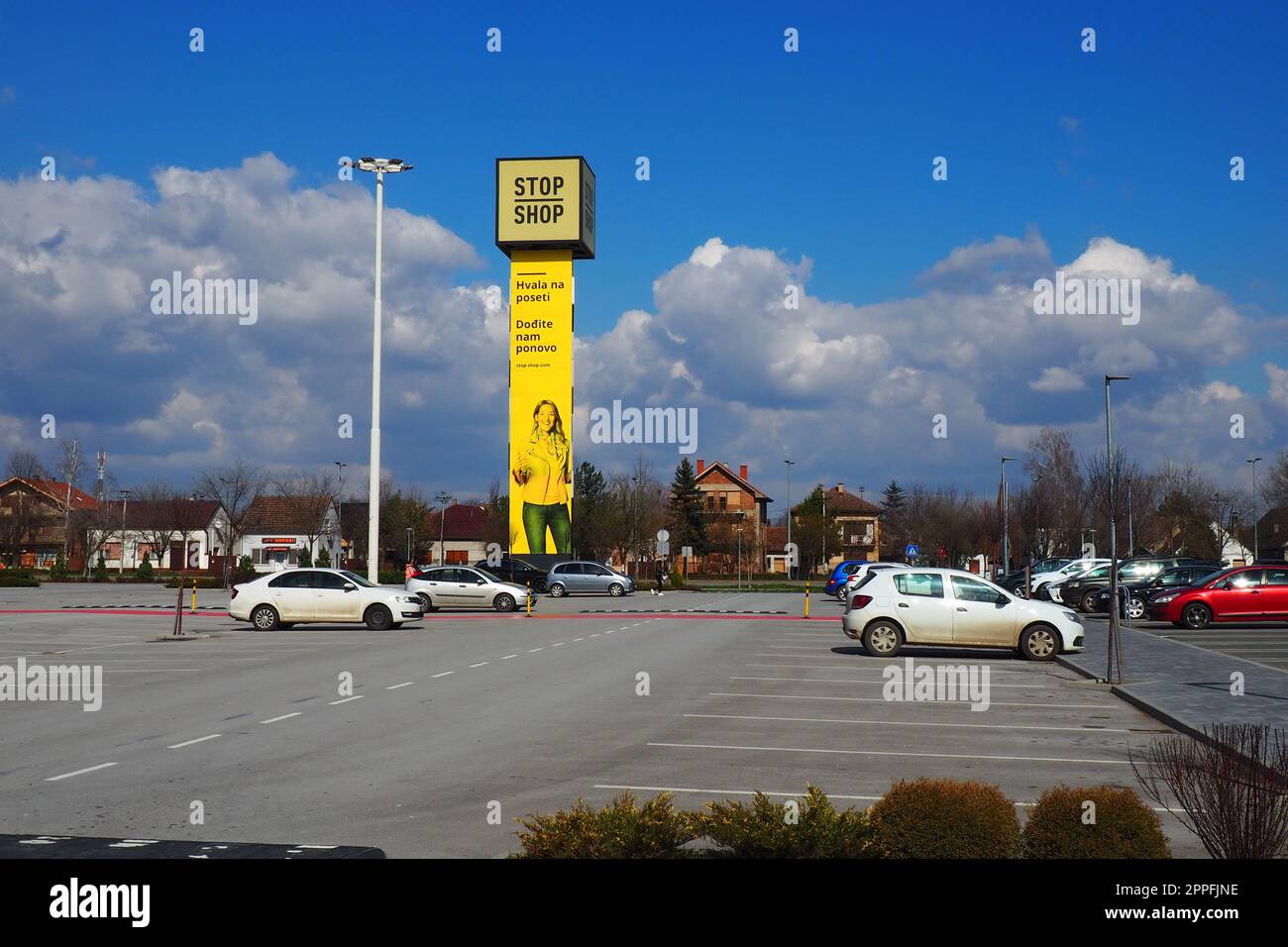 Épicerie Stop and Shop, poteau Stop Shop avec des noms de marque, peint en jaune. Parking devant un grand centre commercial. Sremska Mitrovica, Serbie, 16 mars 2023 Manie du shopping et consumérisme. Banque D'Images