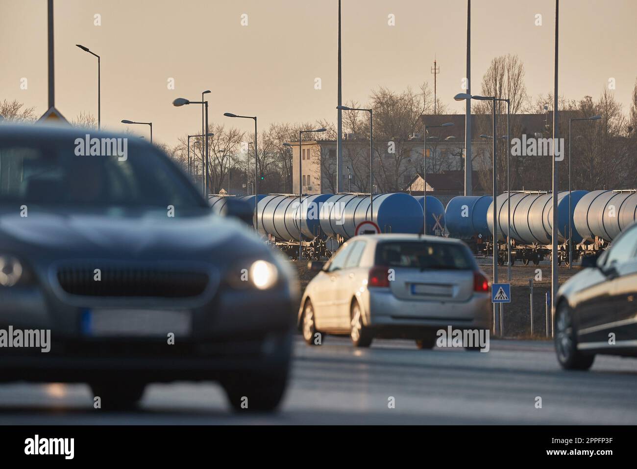 Transport routier et ferroviaire, wagons de fret pétrolier et voitures passant Banque D'Images Transport routier et ferroviaire, wagons de fret pétrolier et voitures passant Banque D'Images